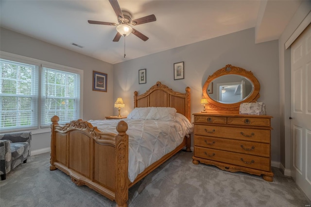 bedroom with carpet flooring, visible vents, ceiling fan, and baseboards