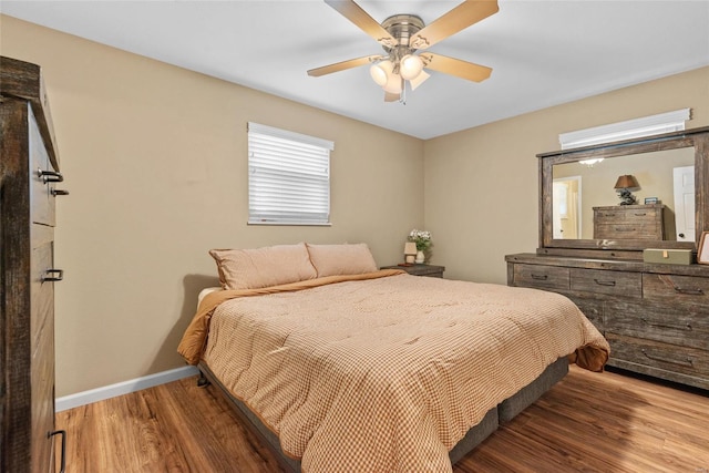 bedroom with baseboards, ceiling fan, and wood finished floors