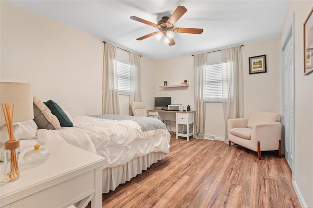 bedroom with light wood finished floors, baseboards, and ceiling fan