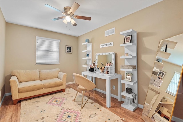 office space with baseboards, visible vents, wood finished floors, and a ceiling fan
