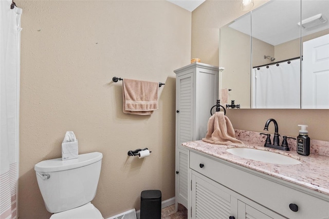 bathroom with toilet, vanity, and a shower with shower curtain