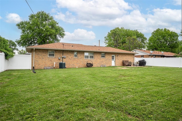 back of property with a yard, a fenced backyard, and brick siding