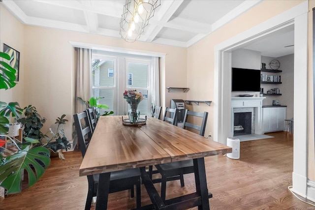 dining space featuring a fireplace with flush hearth, beam ceiling, coffered ceiling, and wood finished floors