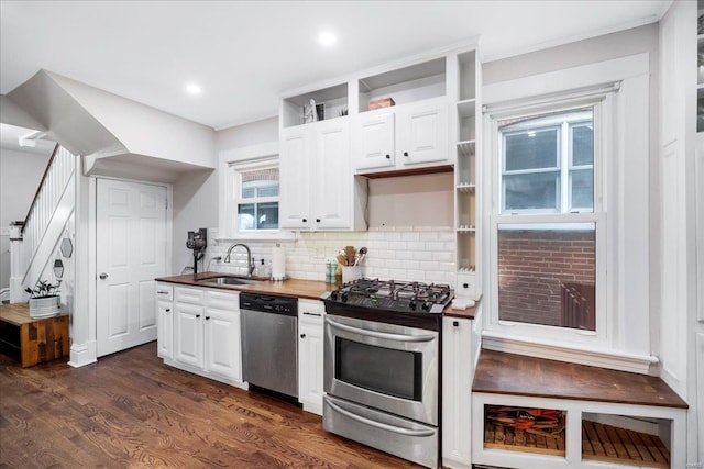kitchen featuring a sink, backsplash, white cabinets, and stainless steel appliances