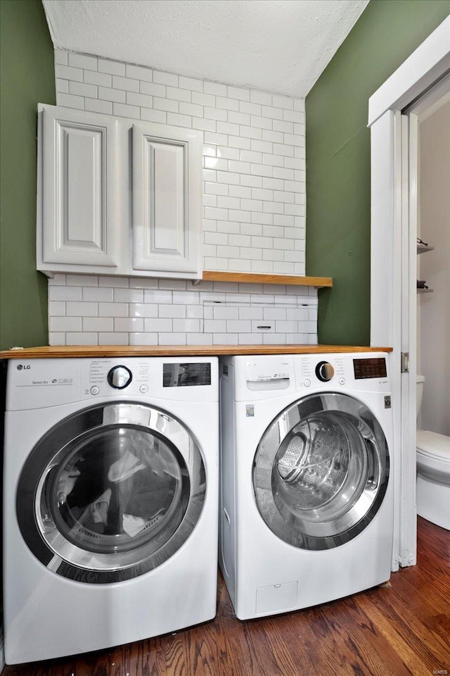 washroom featuring a textured ceiling, dark wood finished floors, and independent washer and dryer