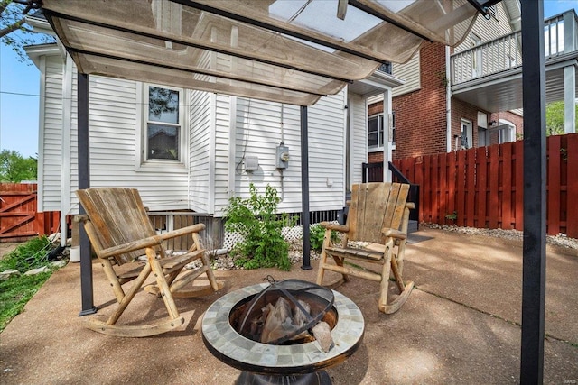 view of patio with a pergola, fence, and a fire pit