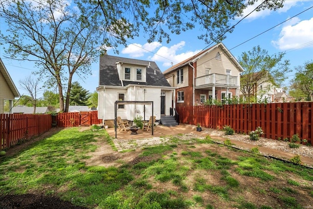 rear view of property with a lawn, a shingled roof, and a fenced backyard