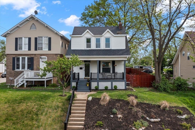 traditional-style house with stairway, fence, a chimney, and a front lawn
