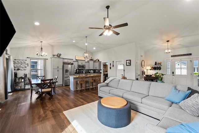 living room with dark wood-style flooring, ceiling fan with notable chandelier, lofted ceiling, and a wealth of natural light