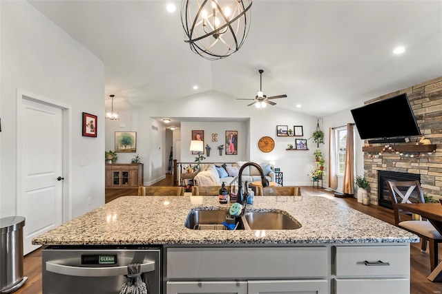 kitchen featuring a kitchen island with sink, vaulted ceiling, dishwasher, a sink, and open floor plan