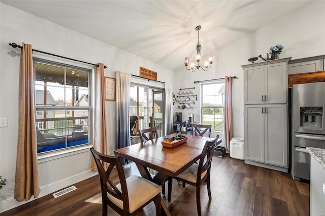 dining space featuring visible vents, baseboards, dark wood-style floors, and an inviting chandelier
