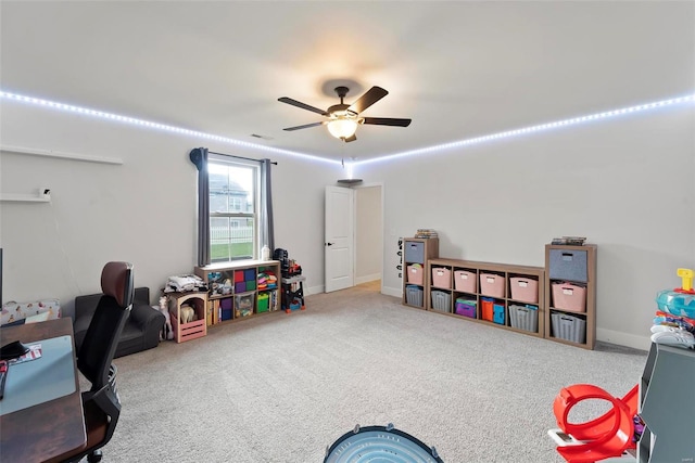 rec room with a ceiling fan, baseboards, and carpet