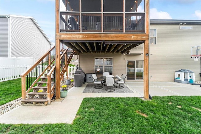 rear view of house featuring stairs, fence, a yard, and a patio