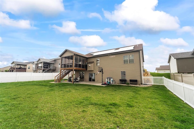 back of property featuring a fenced backyard, a lawn, a patio, and a sunroom
