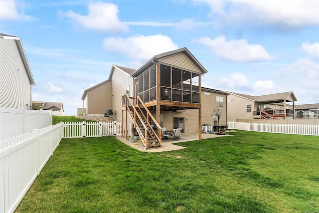 rear view of property featuring a yard, a fenced backyard, a patio area, and a sunroom