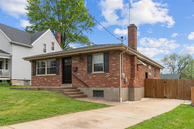 view of front of house with brick siding, a front lawn, fence, and a chimney