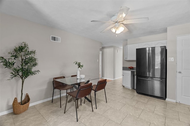 dining space with visible vents, a ceiling fan, baseboards, and light tile patterned flooring