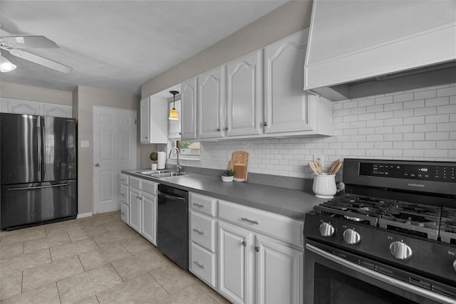 kitchen with stainless steel gas stove, custom range hood, a sink, freestanding refrigerator, and black dishwasher