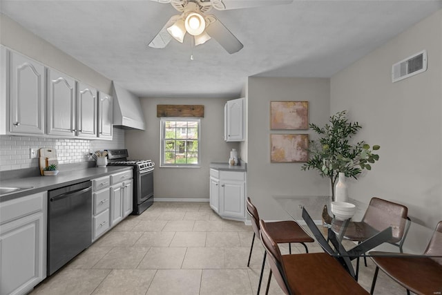 kitchen with visible vents, ceiling fan, gas range oven, wall chimney exhaust hood, and dishwasher