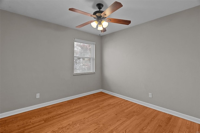 unfurnished room featuring a ceiling fan, baseboards, and light wood-style floors