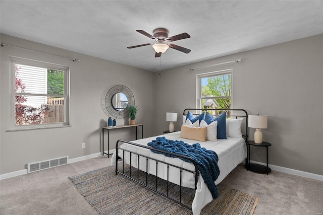 bedroom with baseboards, visible vents, ceiling fan, and carpet