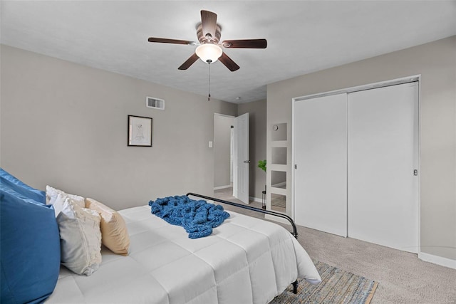 bedroom with a ceiling fan, visible vents, baseboards, a closet, and carpet flooring