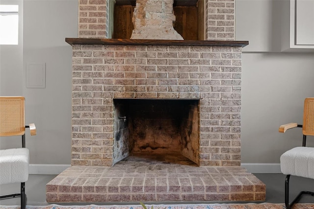 room details featuring baseboards and a fireplace