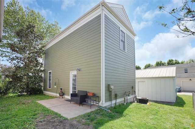 exterior space with a patio area, central AC, an outdoor structure, a storage unit, and a yard