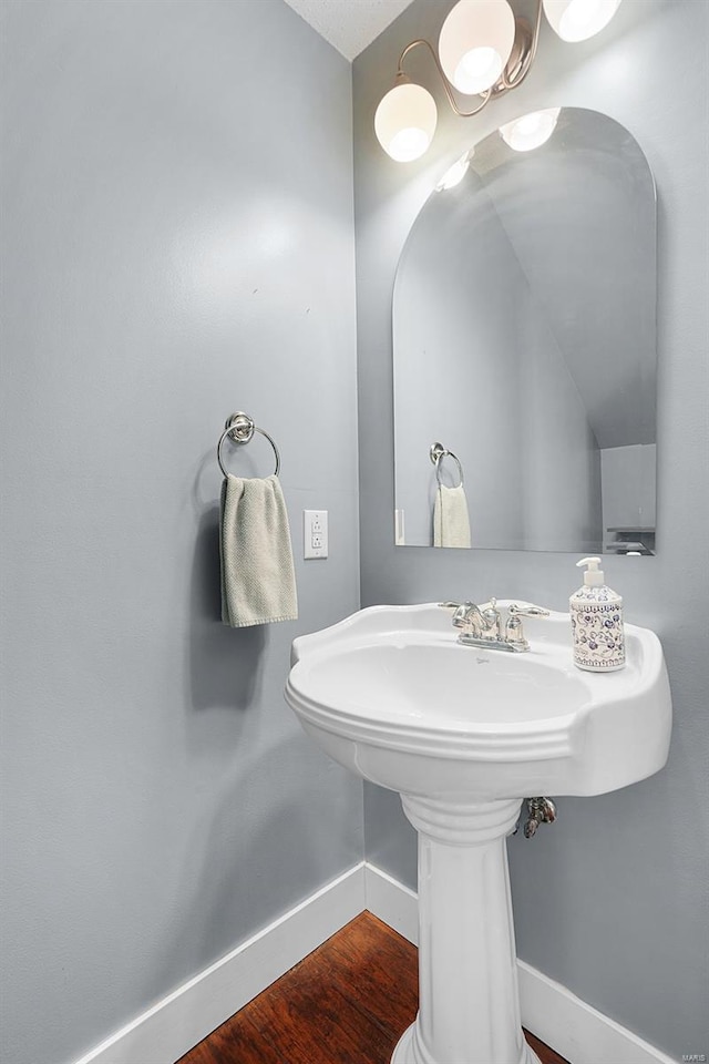 bathroom with baseboards and wood finished floors