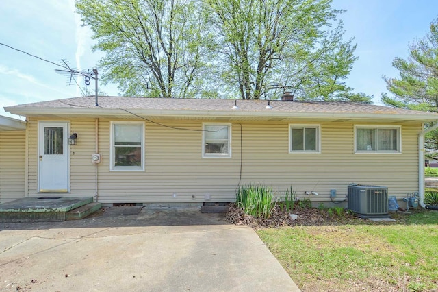 rear view of property featuring a yard and cooling unit