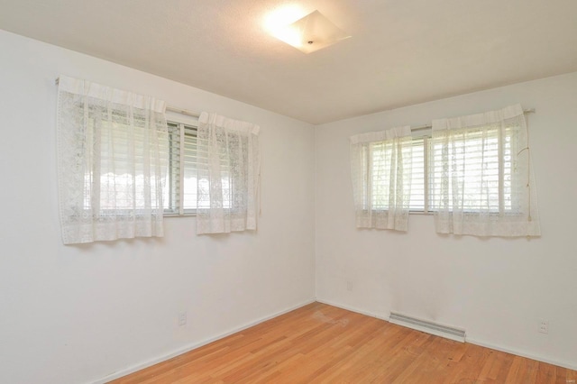 empty room with visible vents, baseboards, and wood finished floors