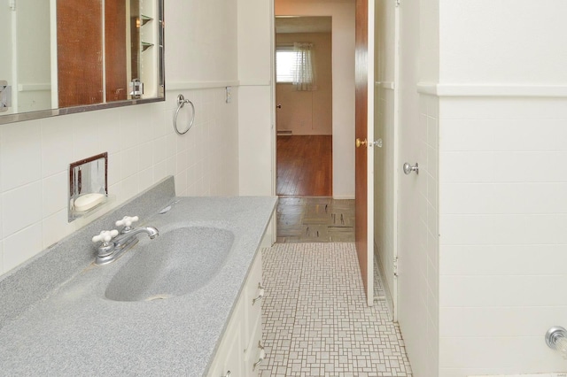 bathroom with tile patterned floors, tile walls, and vanity