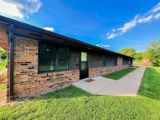 view of front facade with brick siding and a front yard