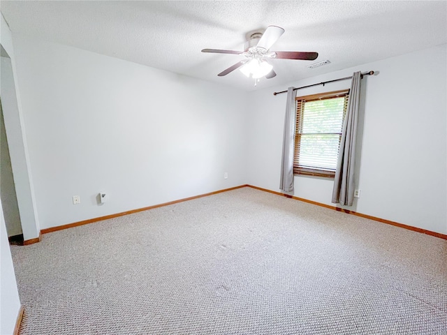 carpeted spare room with a textured ceiling, ceiling fan, visible vents, and baseboards
