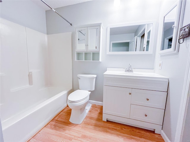 bathroom featuring washtub / shower combination, vanity, toilet, baseboards, and wood finished floors