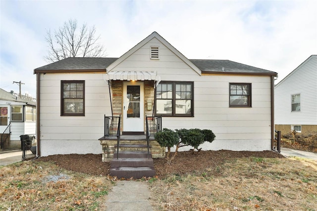 bungalow-style house featuring roof with shingles