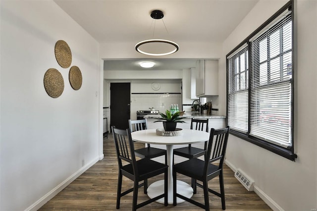 dining area with baseboards, dark wood-style flooring, and visible vents