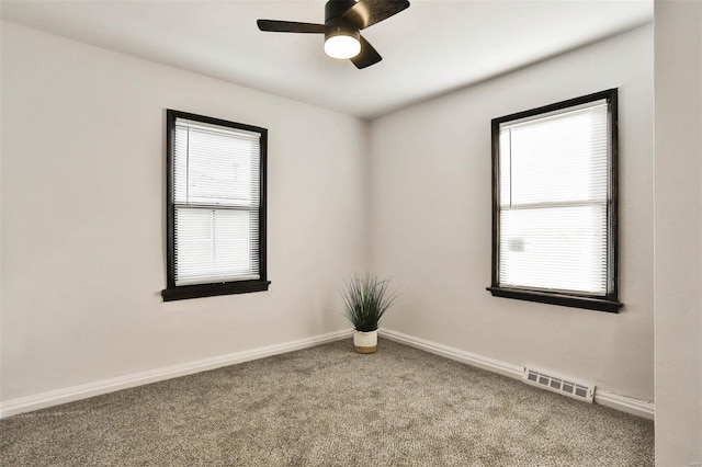 carpeted spare room featuring a ceiling fan, baseboards, and visible vents