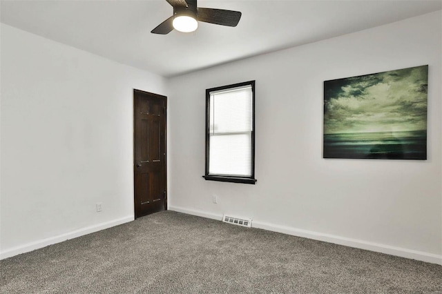 unfurnished room with baseboards, ceiling fan, carpet, and visible vents