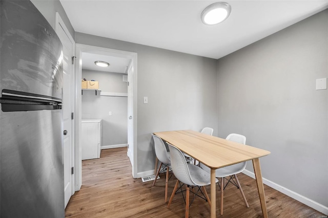 office with baseboards, wood finished floors, and separate washer and dryer