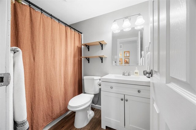 full bathroom featuring toilet, a shower with curtain, wood finished floors, and vanity