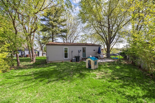 back of property featuring central air condition unit, fence, and a yard