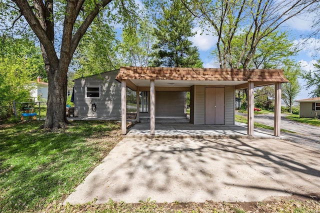 exterior space with a lawn, fence, and a carport