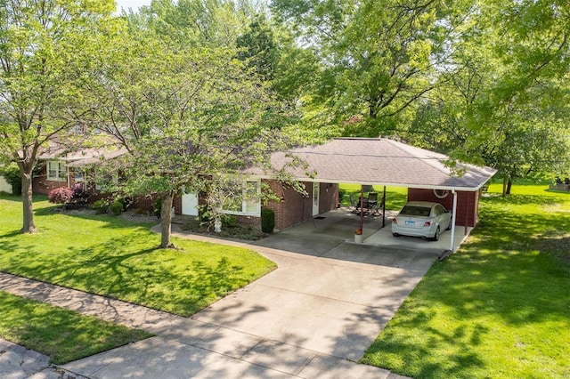 single story home featuring brick siding, concrete driveway, a front yard, and a carport