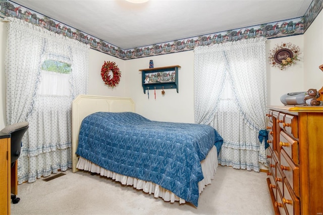 carpeted bedroom featuring visible vents