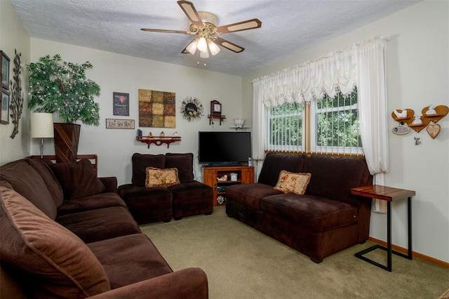 living area with baseboards, a textured ceiling, carpet, and ceiling fan