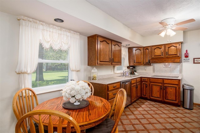 kitchen featuring ceiling fan, brown cabinets, dishwasher, light countertops, and a sink