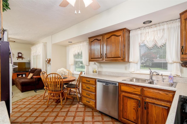 kitchen featuring light countertops, ceiling fan, a sink, and dishwasher
