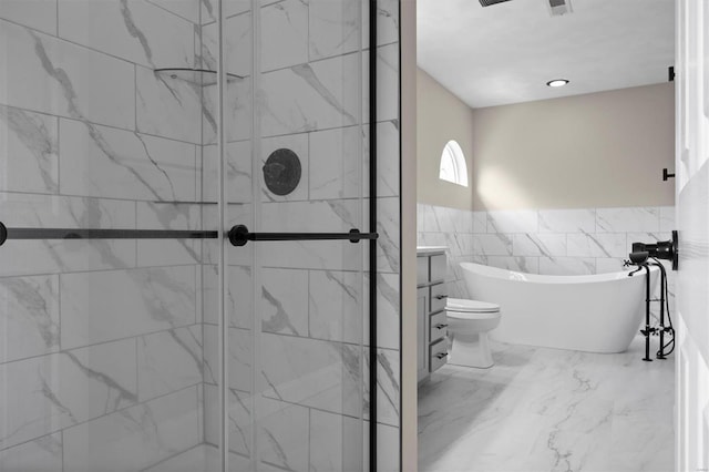 full bathroom featuring a freestanding bath, a wainscoted wall, a shower stall, and marble finish floor