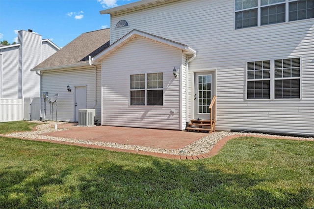 rear view of house featuring entry steps, central AC unit, a yard, and a patio area